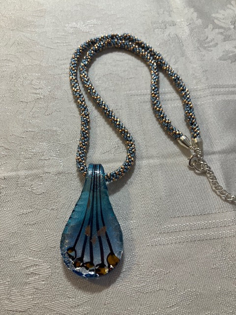 Kumihimo necklace with a light blue and copper glass pendant